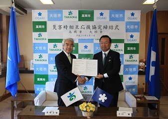 かたく握手をかわす髙橋正樹高岡市長(左)と小川敏大垣市長(右)