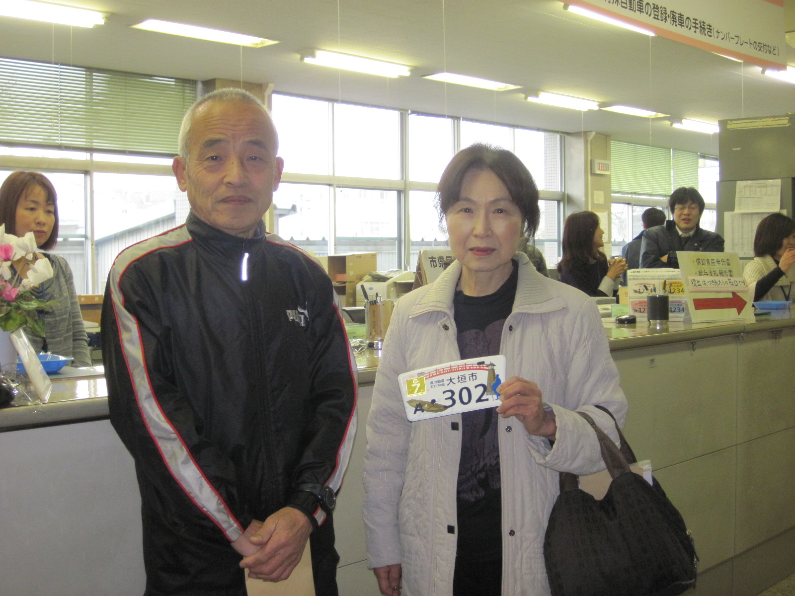 ナンバープレートを持って記念写真