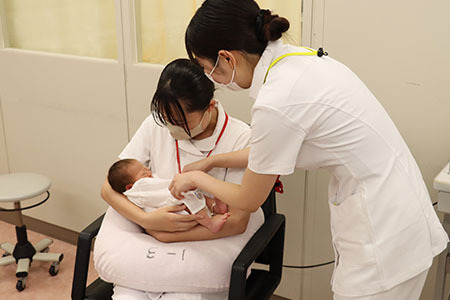 新生児の抱っこを体験する高校生