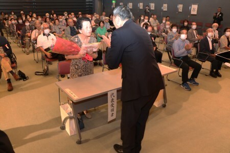 市長から花束と記念品を受け取る浅井さん