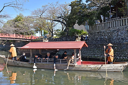 献句を書いたハマグリ形の色紙を水門川に流す石田市長ら